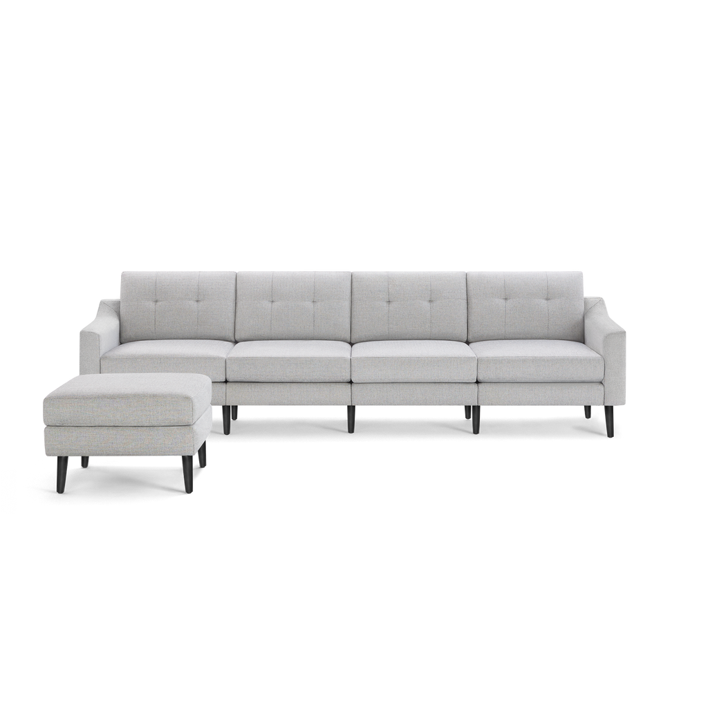 Light gray modern sectional sofa with tufted cushions and black wooden legs, paired with a matching ottoman.