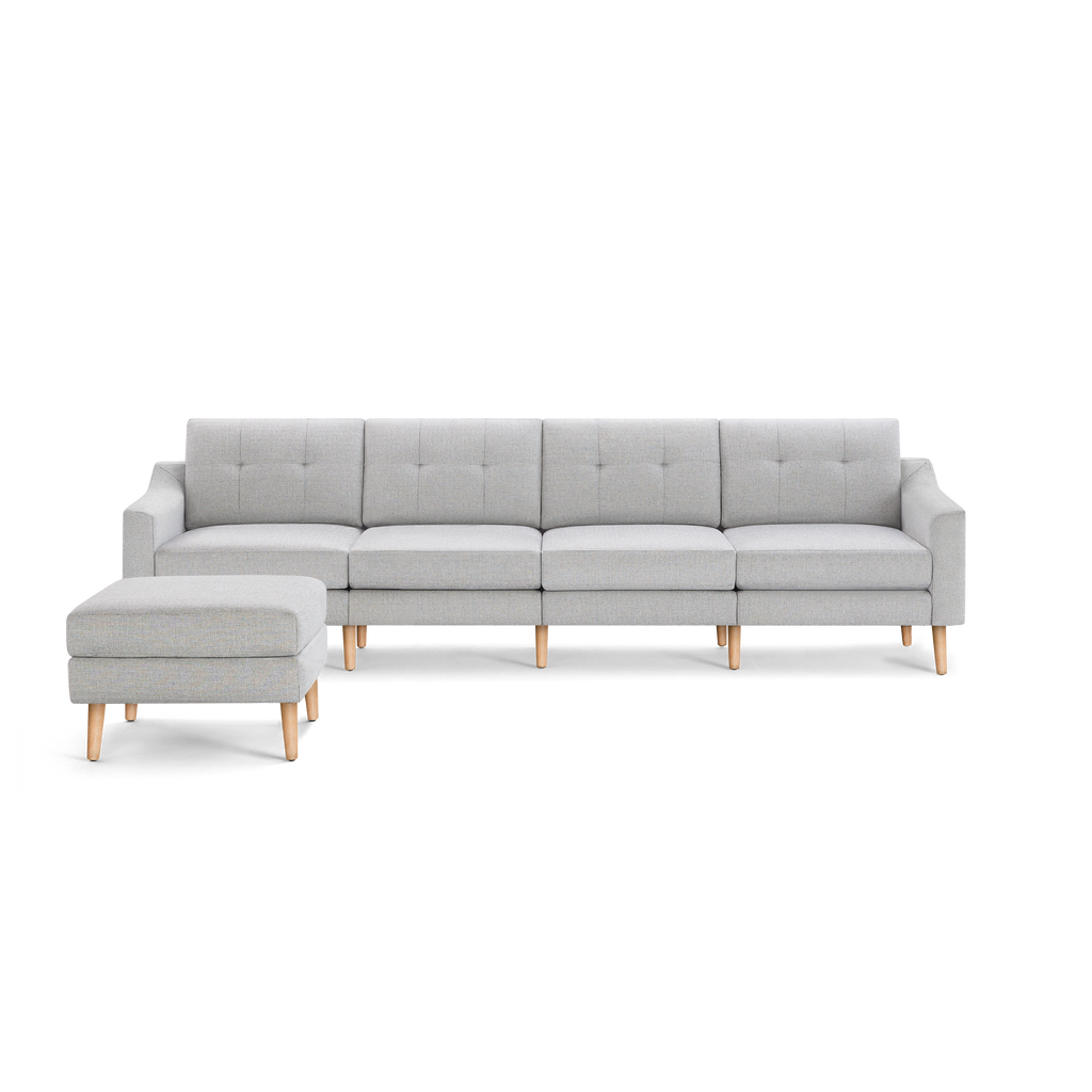 Light gray modern sectional sofa with tufted cushions, wooden legs, and a matching ottoman on the left side.