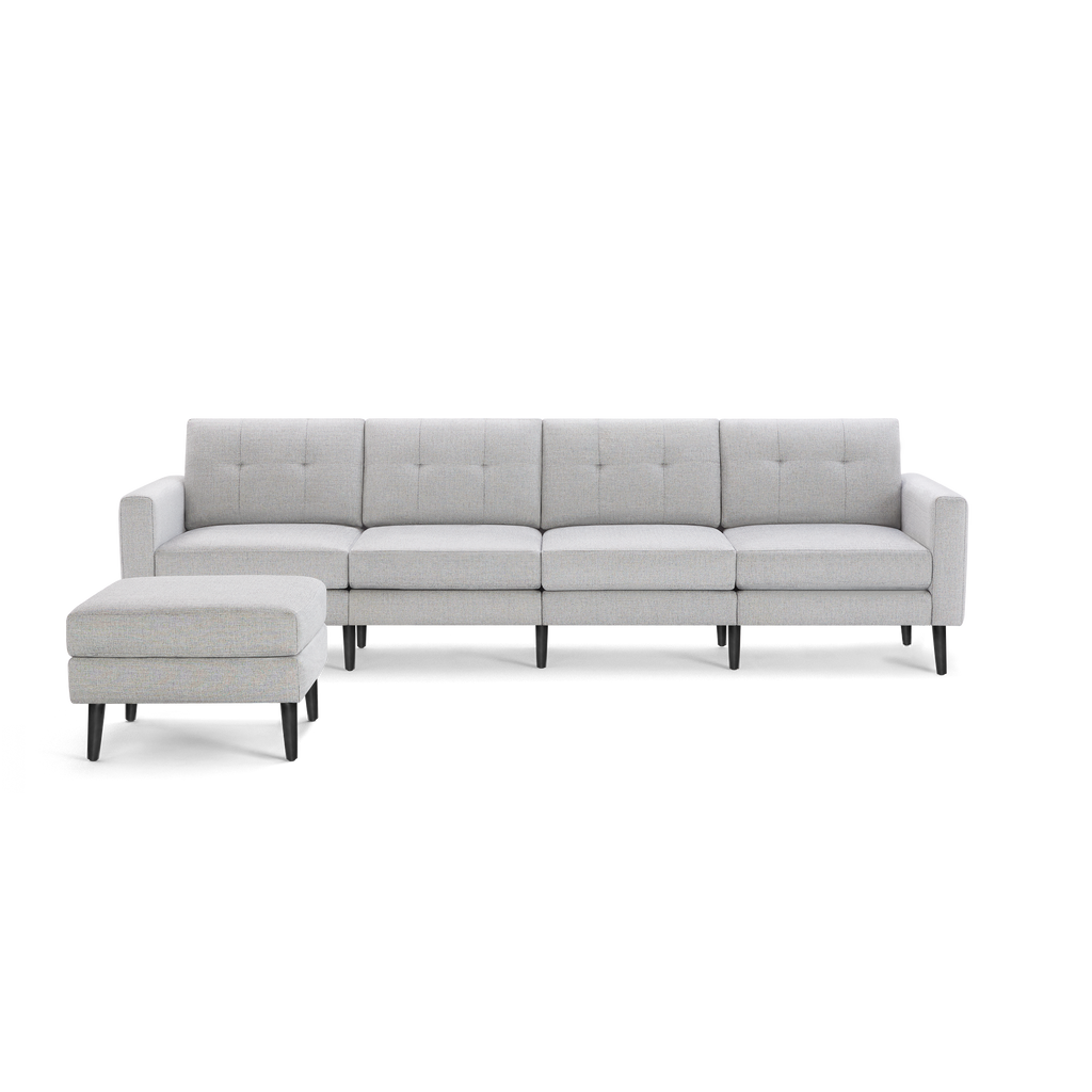 Light gray modern sectional sofa with tufted back cushions and matching ottoman, supported by black tapered legs.