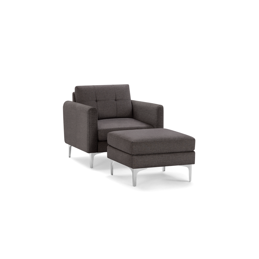 Modern dark gray upholstered armchair with a matching ottoman, featuring clean lines and silver metal legs.