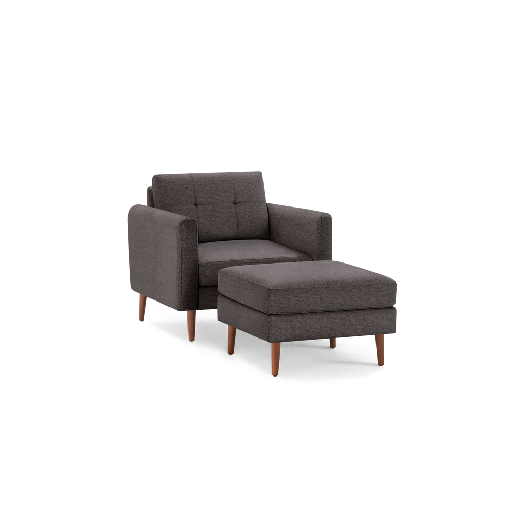 Modern dark gray fabric armchair with matching ottoman, featuring wooden legs and tufted backrest for stylish comfort.
