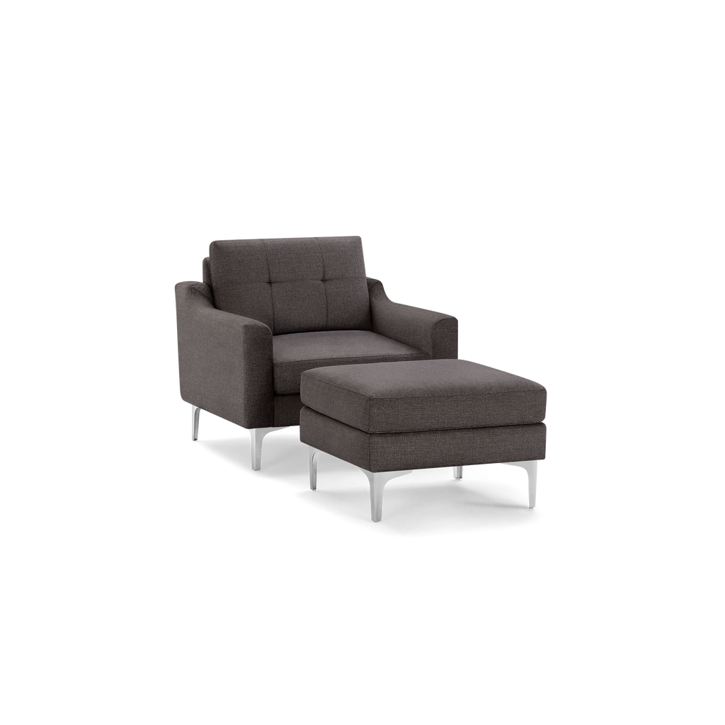 Dark gray upholstered armchair with matching cushioned ottoman, both featuring sleek metal legs and modern design.