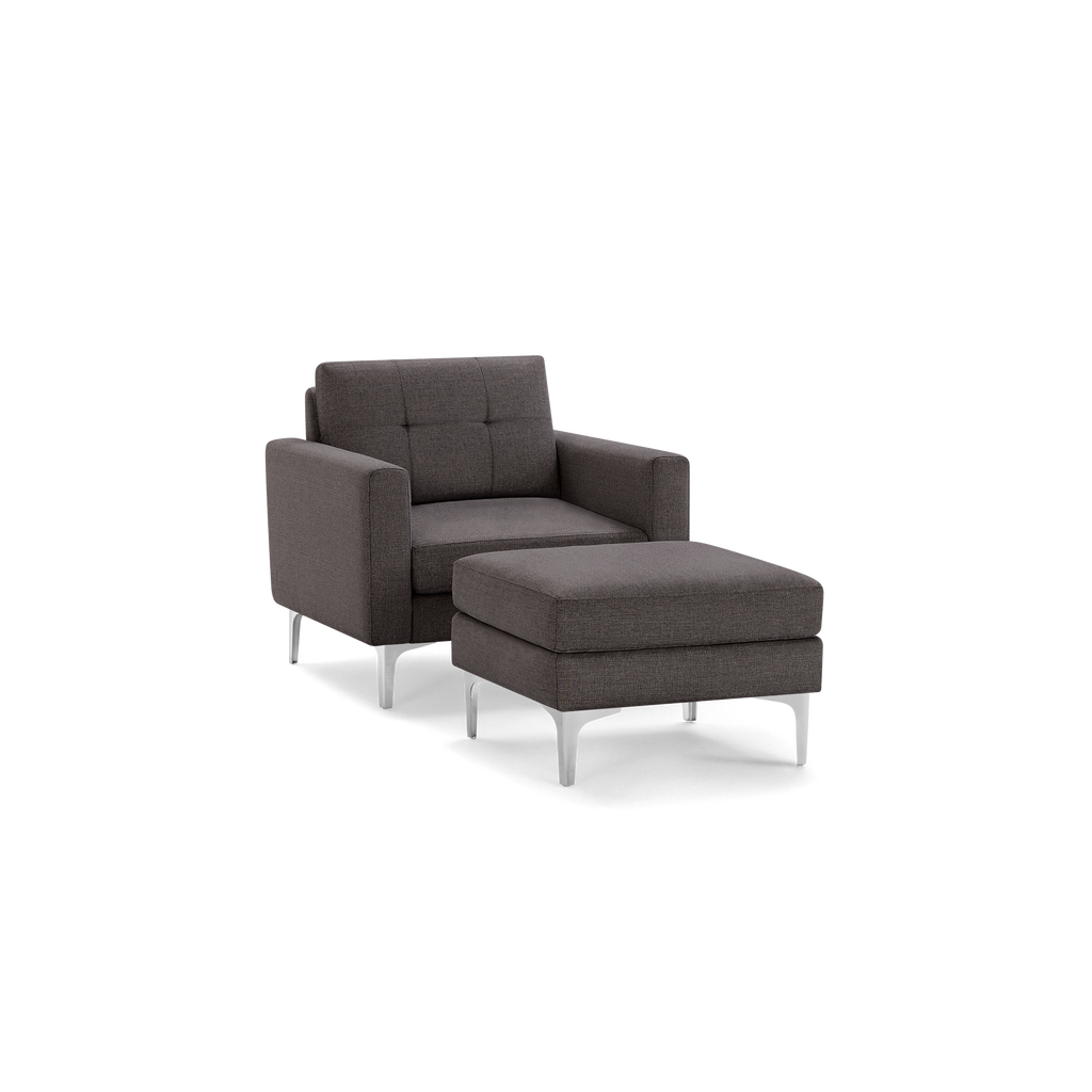 Modern dark gray fabric armchair with matching cushioned ottoman, tufted backrest, and sleek silver metal legs.