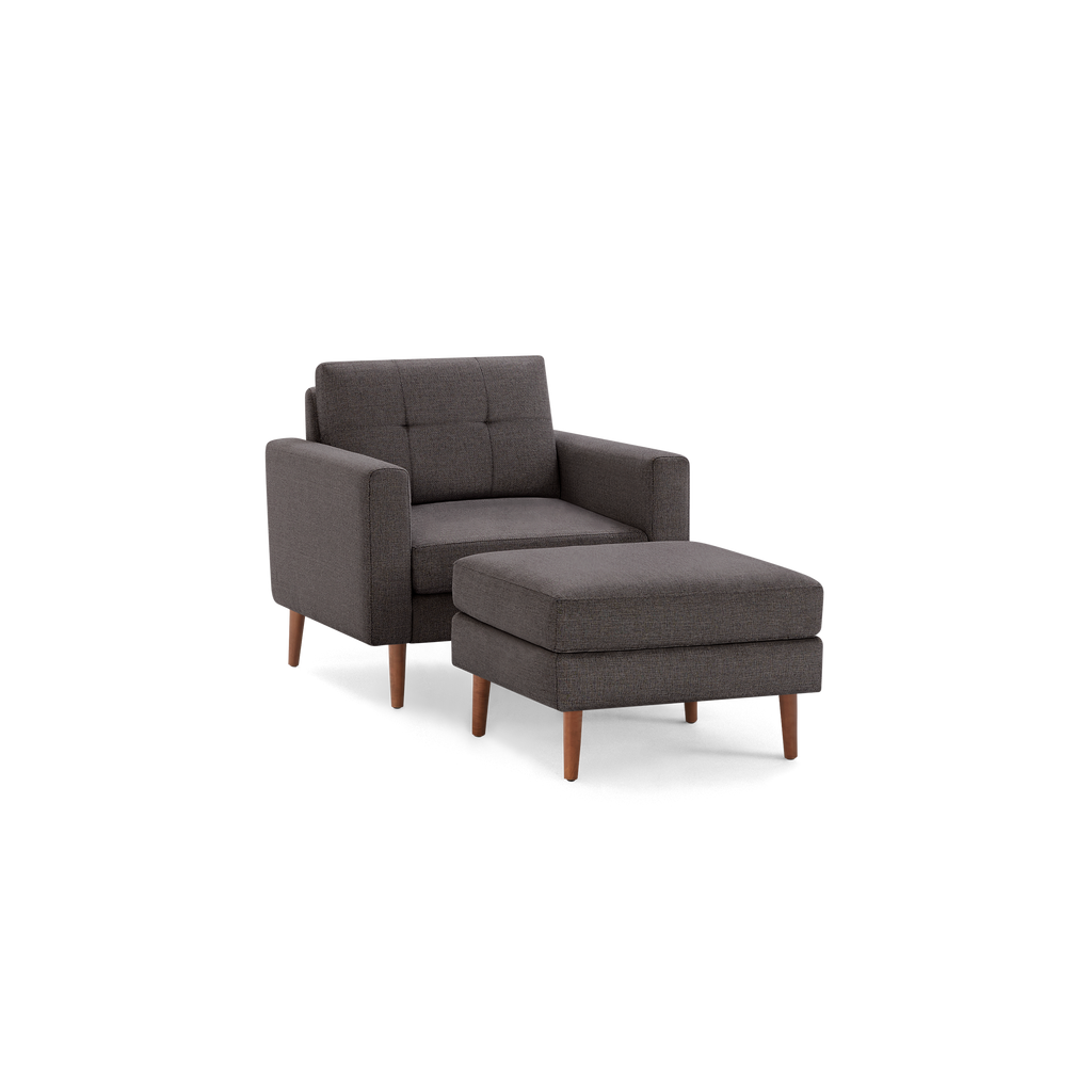 Gray upholstered armchair with matching ottoman, featuring wooden legs and a tufted backrest.