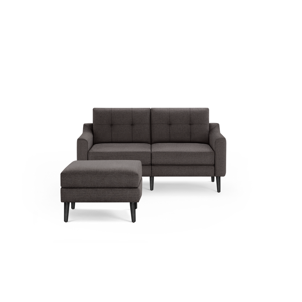 Dark gray fabric loveseat sofa with a matching ottoman, featuring button-tufted back cushions and black tapered legs.