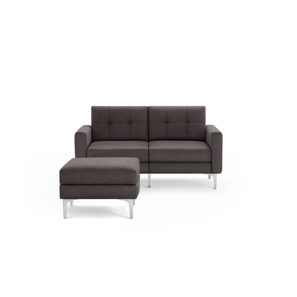 Modern dark gray fabric loveseat sofa with tufted backrest and matching ottoman, featuring sleek metal legs.