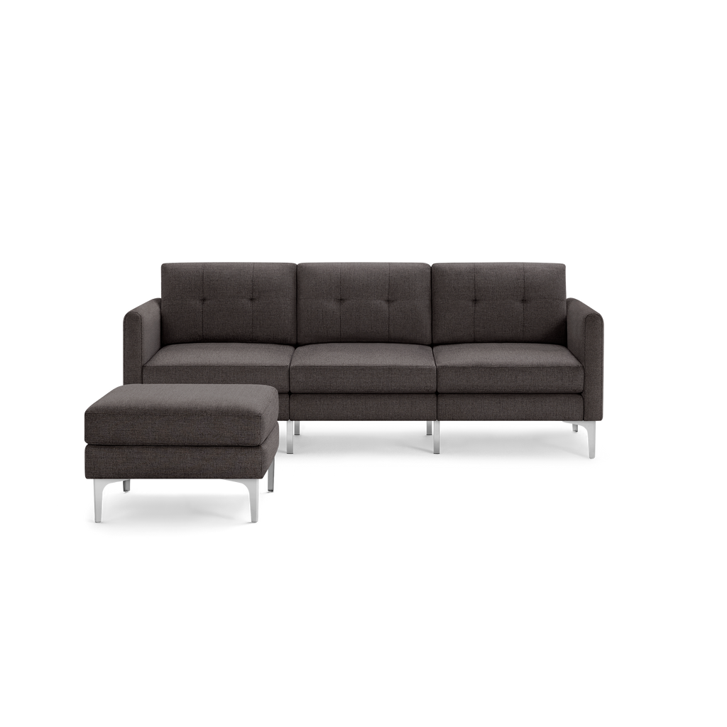 Modern dark gray fabric sectional sofa with tufted back cushions and silver metal legs, featuring a matching ottoman.