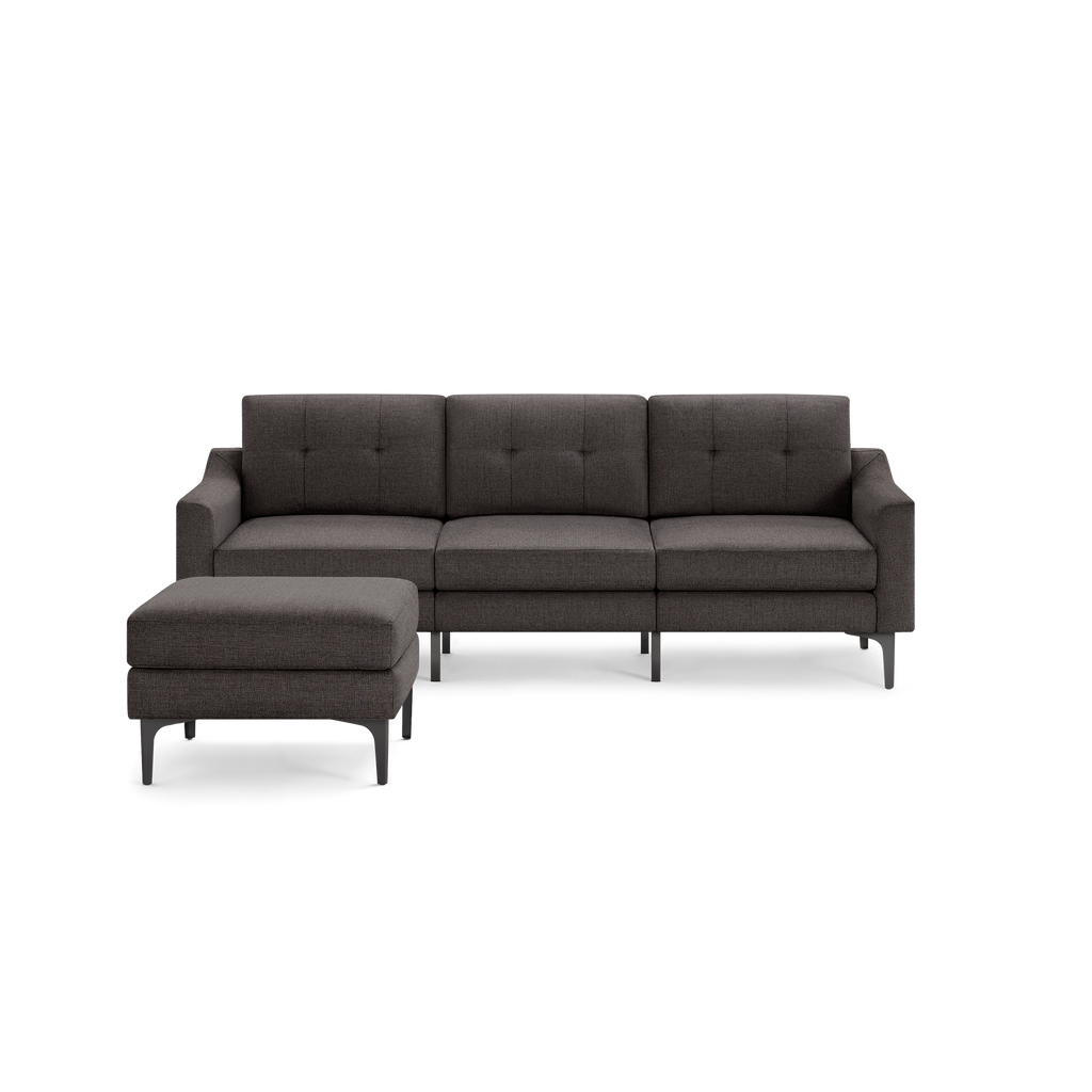 Dark gray modern three-seater sofa with tufted back cushions and a matching ottoman, featuring sleek metal legs.