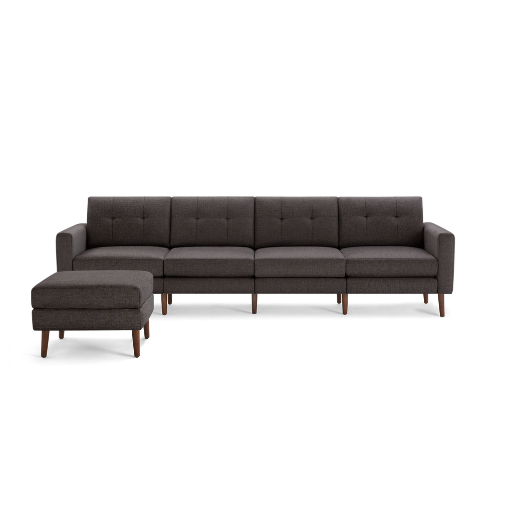 Modern dark gray fabric sectional sofa with tufted back cushions and matching ottoman on wooden legs.