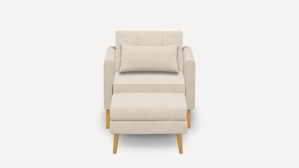 Front view of a beige upholstered armchair with a matching ottoman and rectangular cushion, featuring wooden legs.