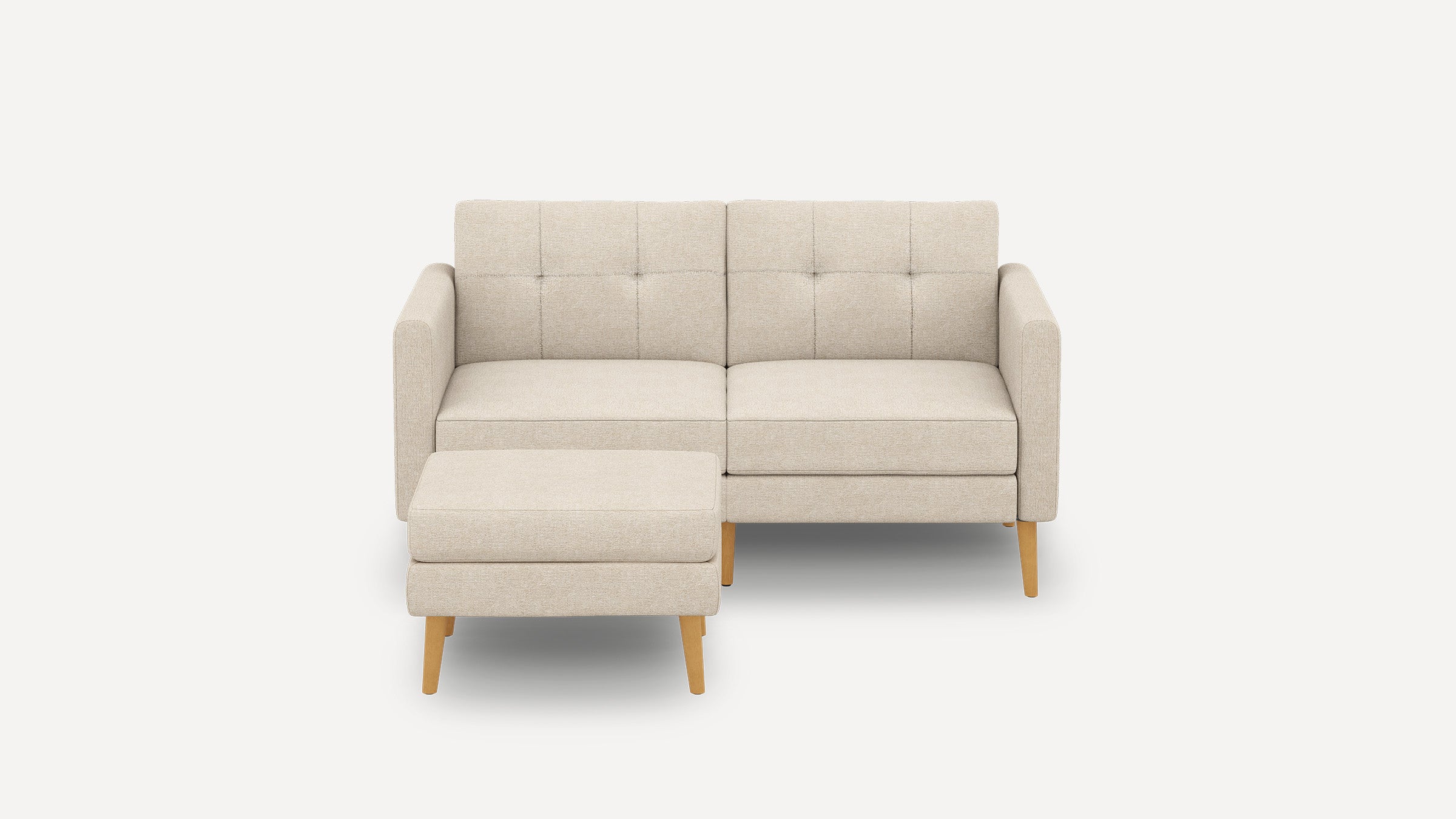 Beige modern two-seater sofa with tufted backrest and matching ottoman, featuring light wooden legs and clean-lined design.