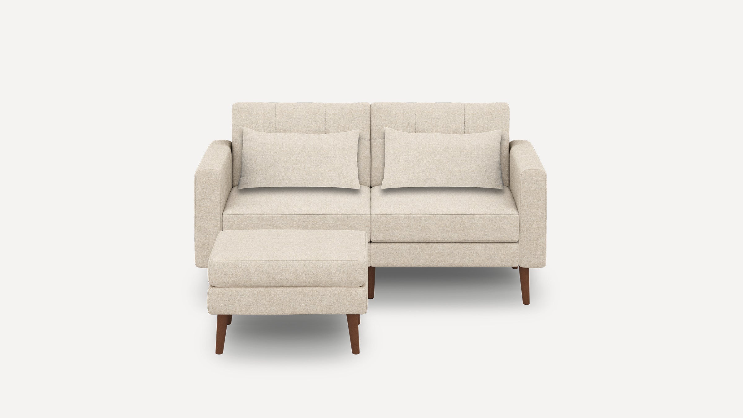 Modern beige two-seater sofa with matching rectangular cushions and a separate cushioned ottoman, supported by wooden legs.
