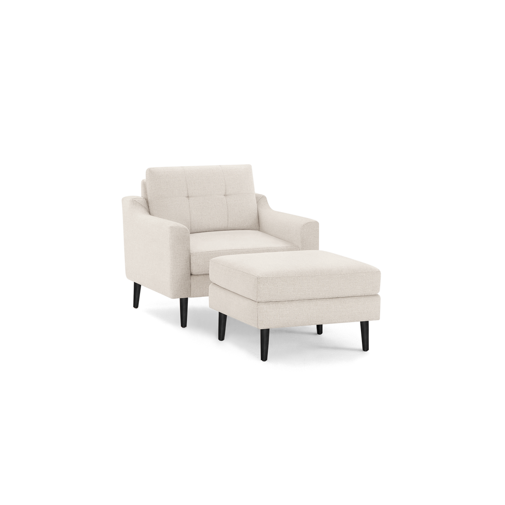 Beige upholstered armchair with button-tufted backrest and matching ottoman, supported by dark wooden legs.