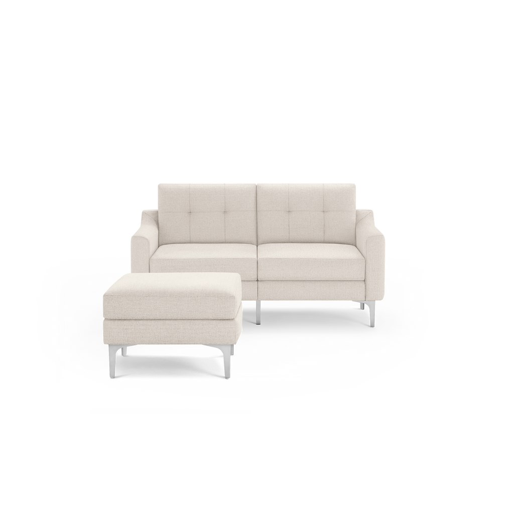 Beige modern two-seater sofa with tufted backrest and matching ottoman, featuring sleek metal legs.