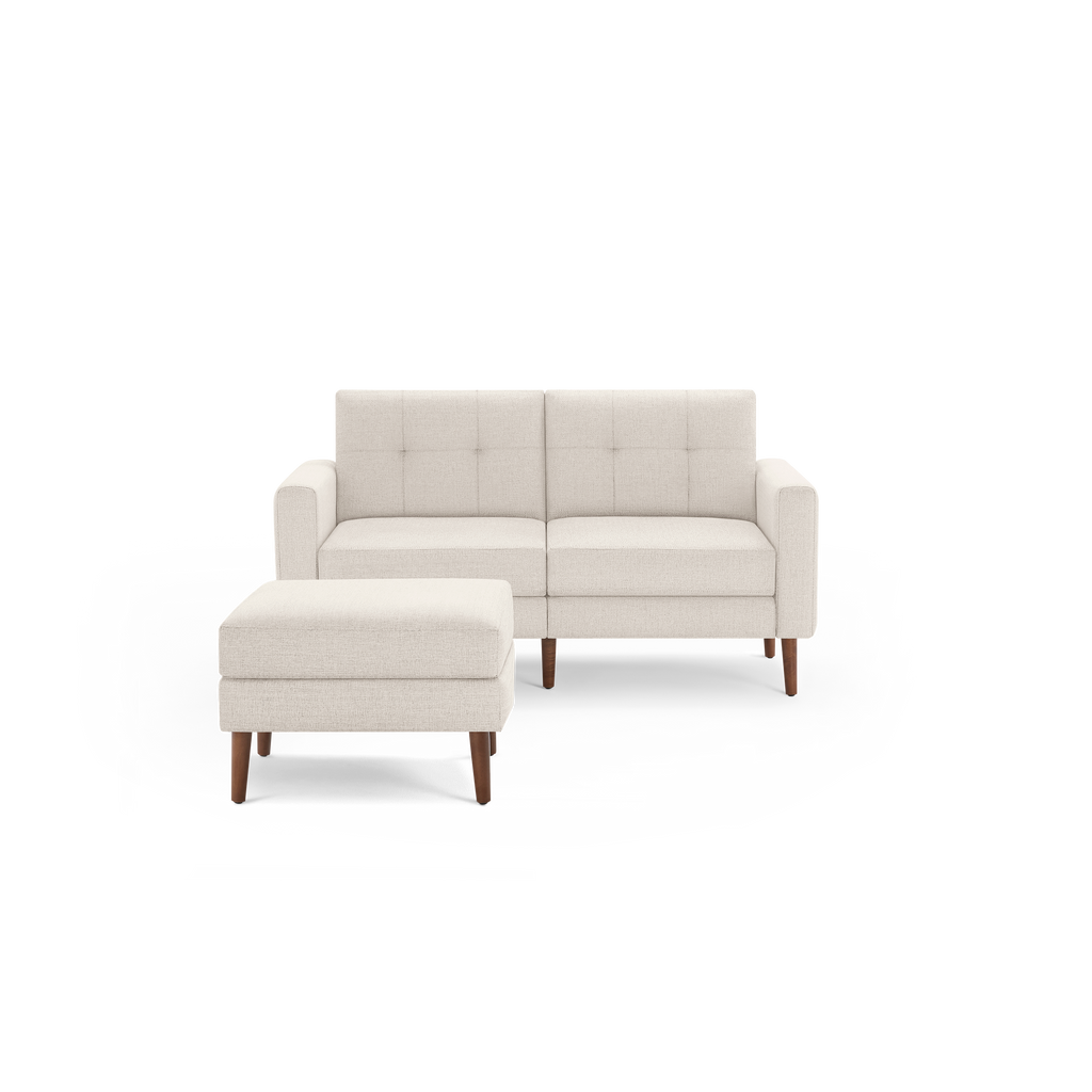 Cream-colored modern loveseat with tufted back cushions and matching rectangular ottoman, supported by wooden legs.