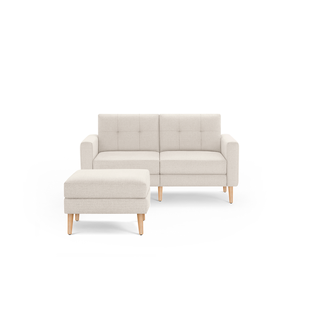 Beige modern loveseat sofa with tufted back cushions and matching ottoman, featuring wooden legs and clean lines.