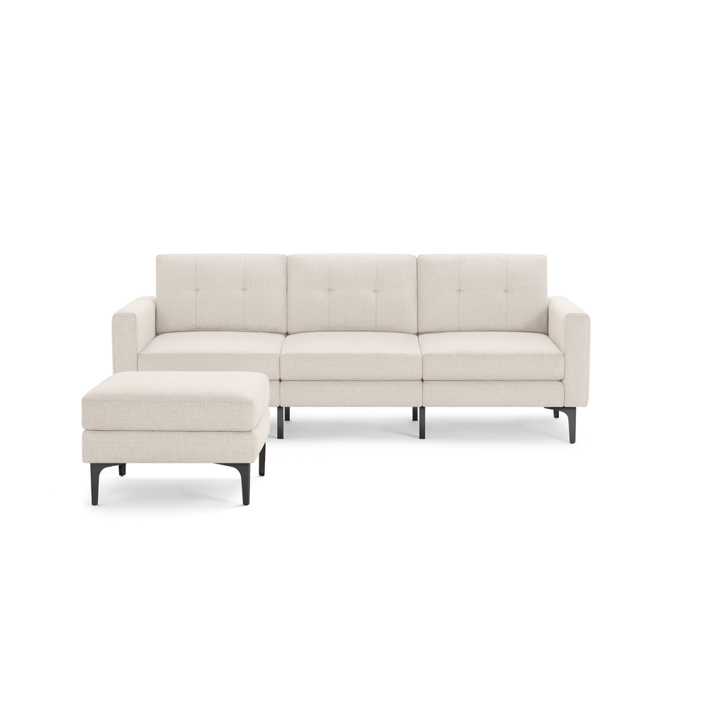 Modern L-shaped beige fabric sectional sofa with tufted back cushions and black metal legs, including a matching ottoman.