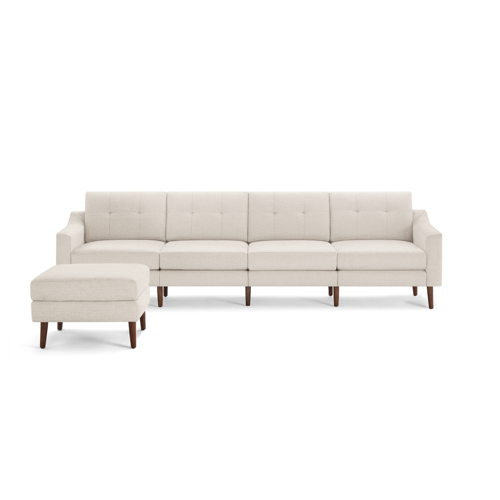 Beige fabric sectional sofa with tufted back cushions, wooden legs, and a matching ottoman on the left side.