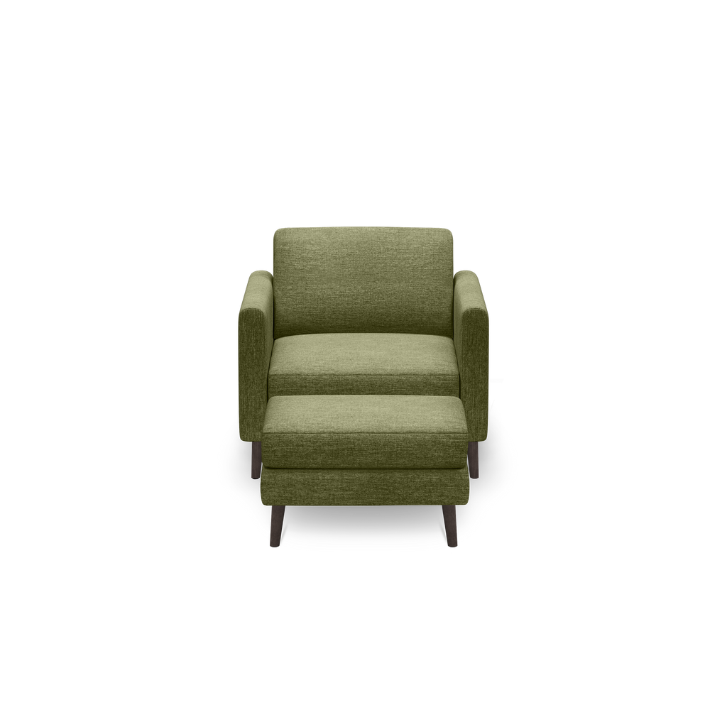 Front view of a modern olive green upholstered armchair with wooden legs and clean lines on a black background.