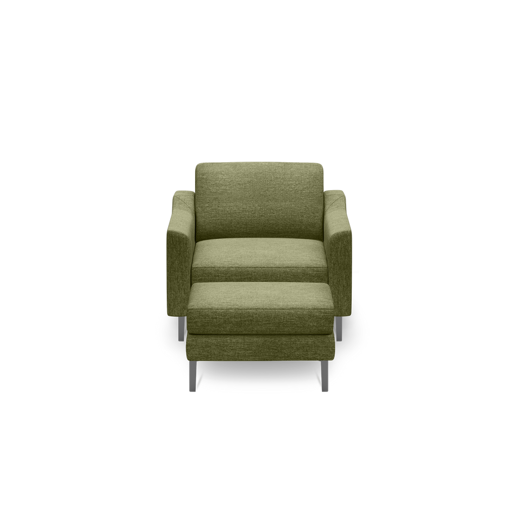 Green upholstered armchair with matching ottoman, featuring clean lines and silver metal legs against a black background.