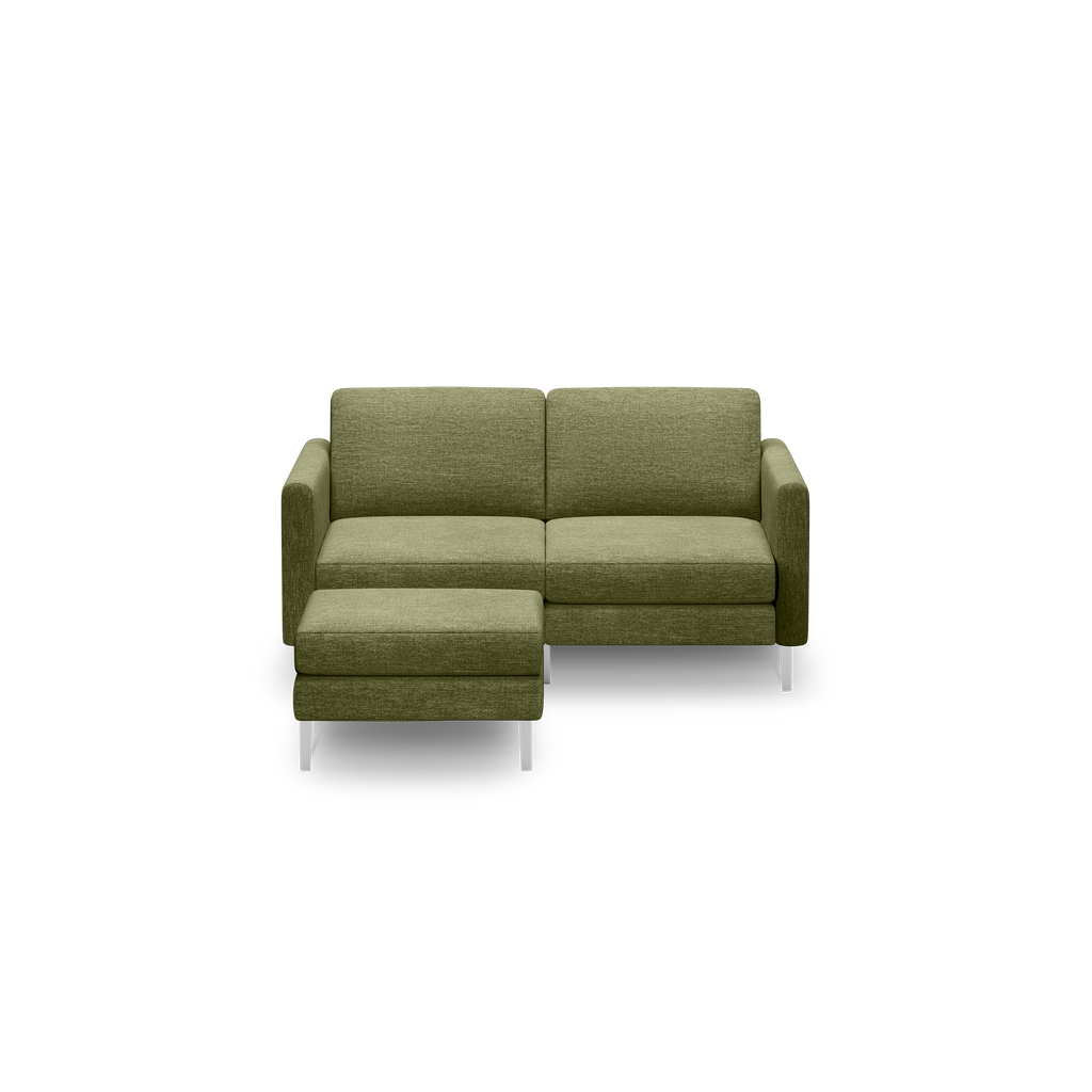 Modern olive green fabric sectional sofa with chaise lounge and sleek silver metal legs, shown on black background.