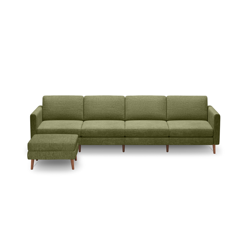 Green upholstered modern sectional sofa with wooden legs and matching ottoman on a black background.
