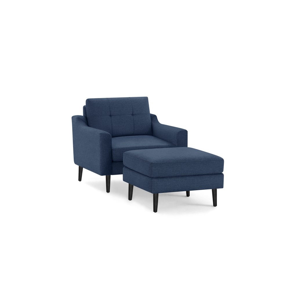 Blue upholstered armchair with tufted backrest and matching ottoman, both featuring tapered black wooden legs.
