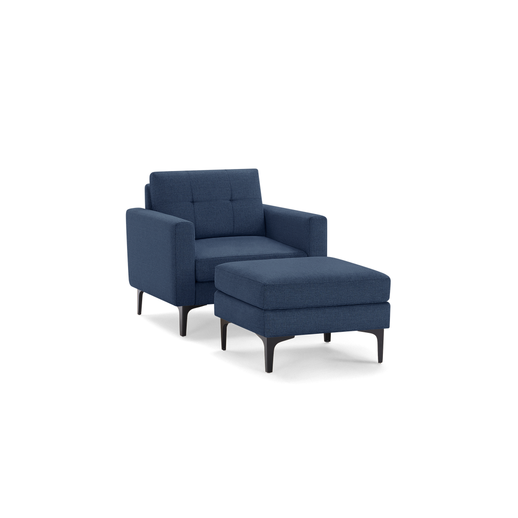 Modern navy blue armchair with matching ottoman, featuring tufted cushions and sleek black legs for stylish comfort.
