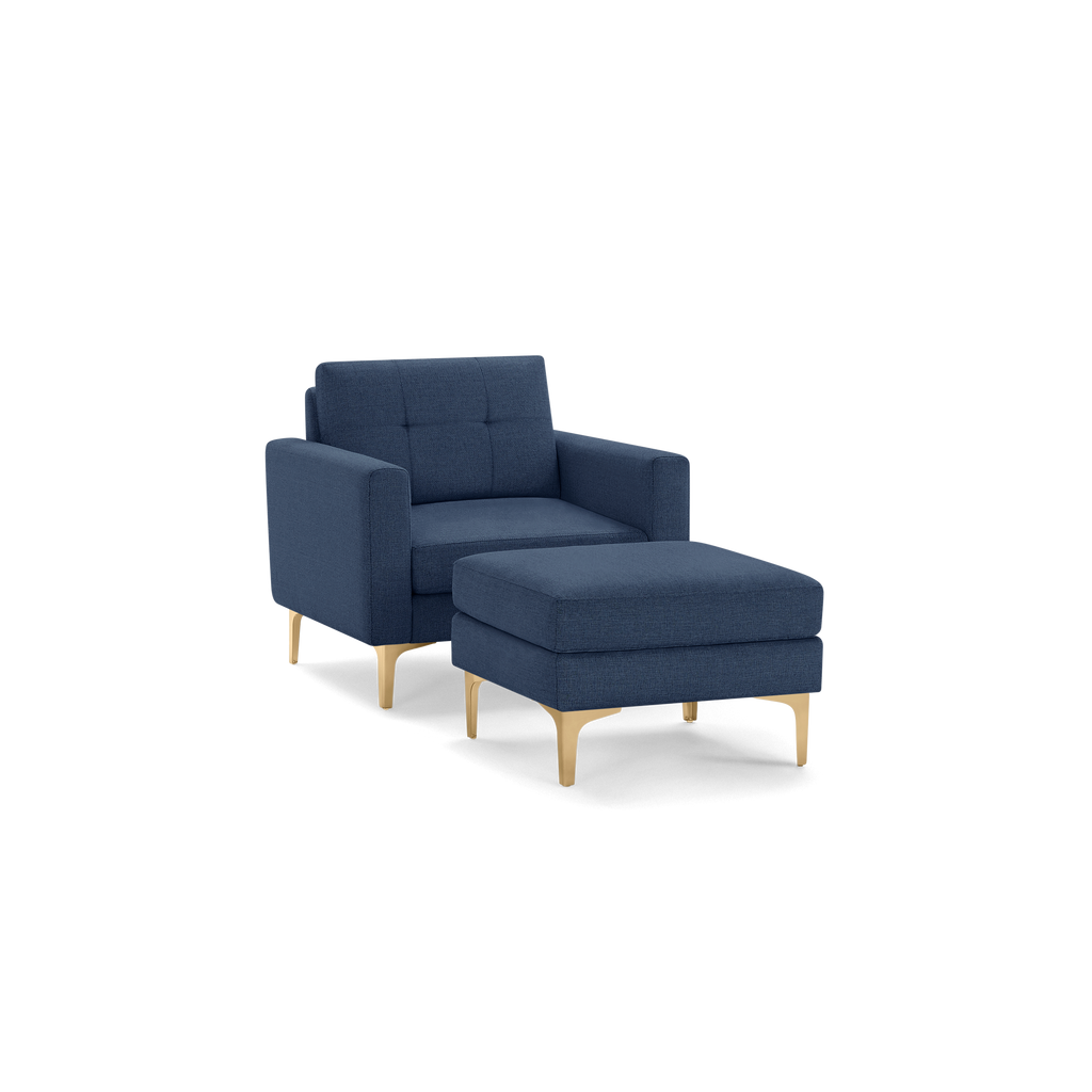 Modern navy blue upholstered armchair with matching ottoman, featuring square arms and light wooden legs.
