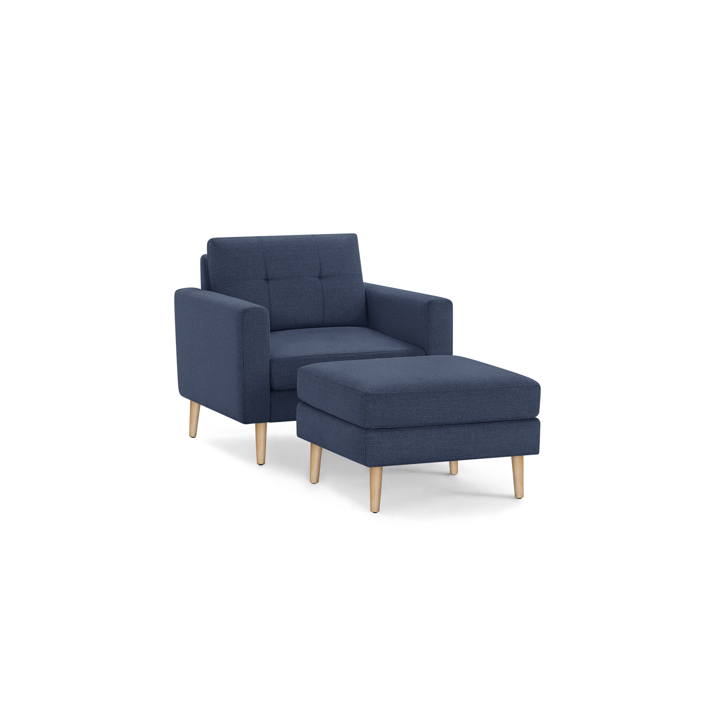 Modern navy blue fabric armchair with matching cushioned ottoman, tufted backrest, and light wooden legs isolated on black background.