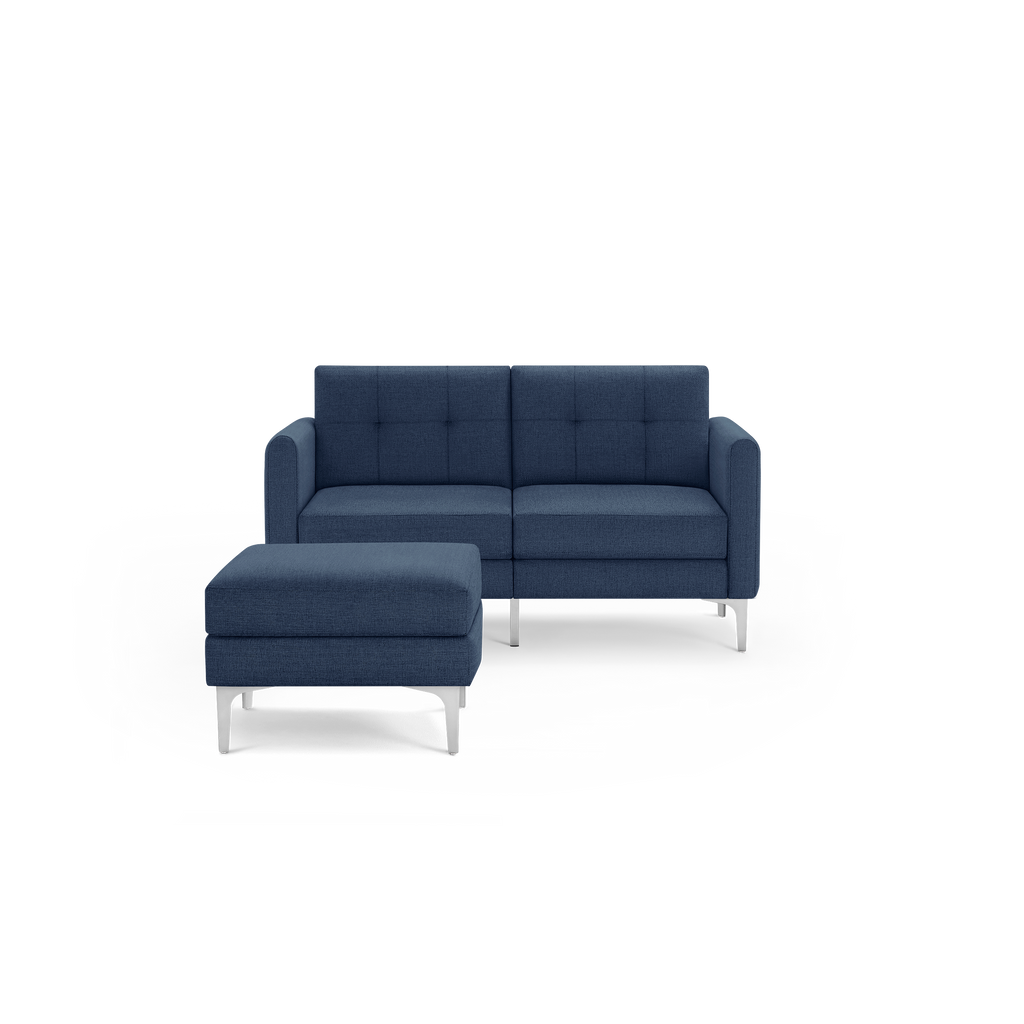 Modern blue fabric loveseat with tufted back cushions and matching ottoman, supported by sleek silver metal legs.