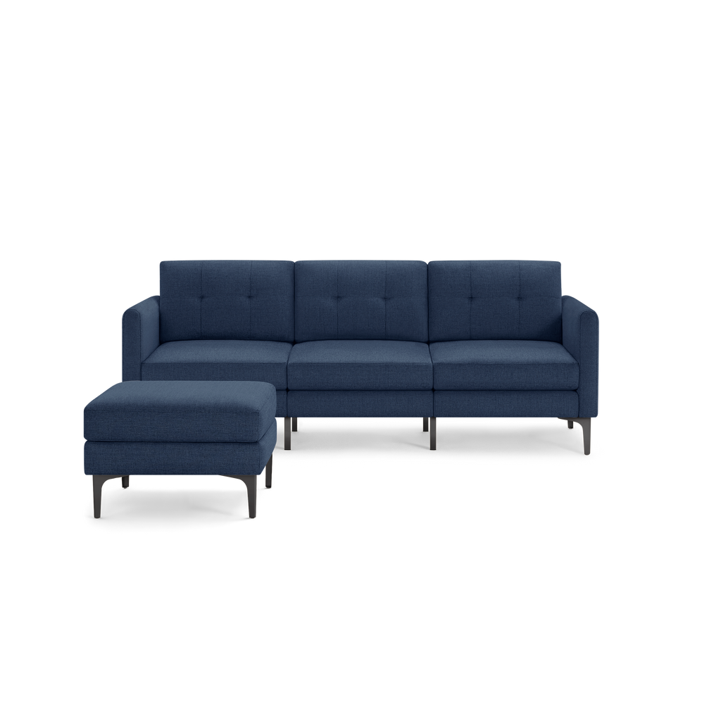 Modern navy blue fabric sectional sofa with tufted back cushions and black metal legs, accompanied by a matching upholstered ottoman.