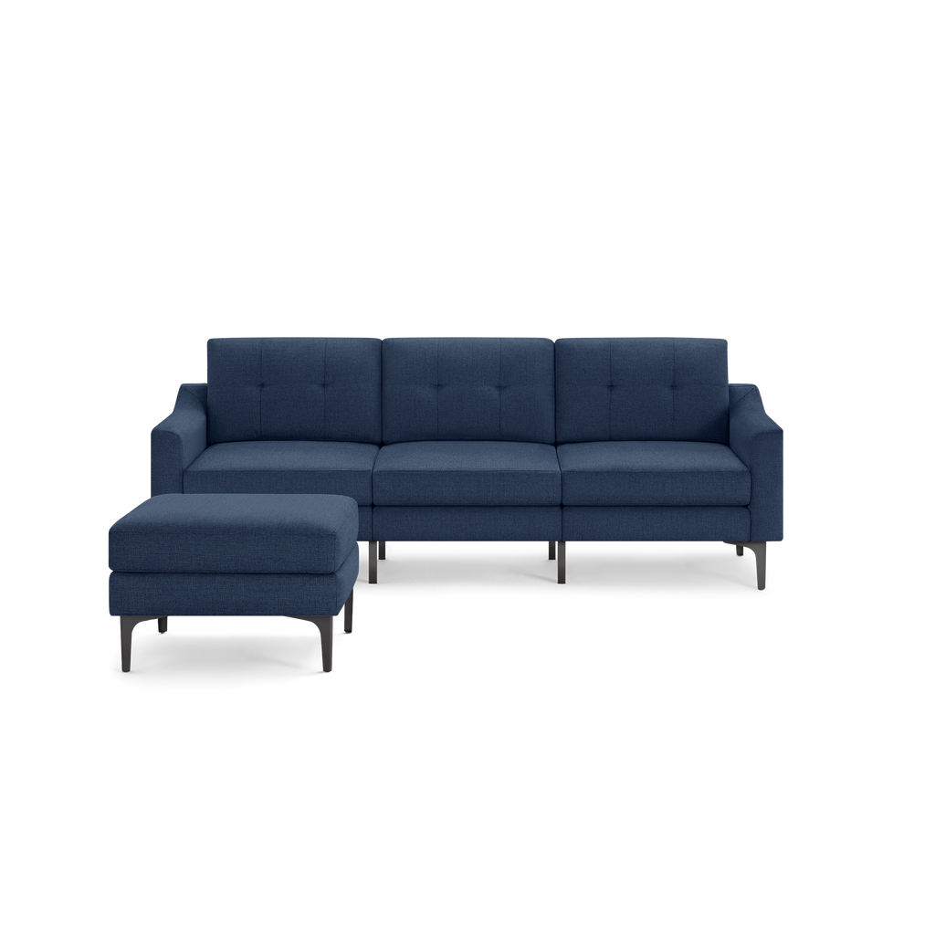 Modern navy blue fabric sectional sofa with tufted back cushions and matching ottoman on sleek metal legs.