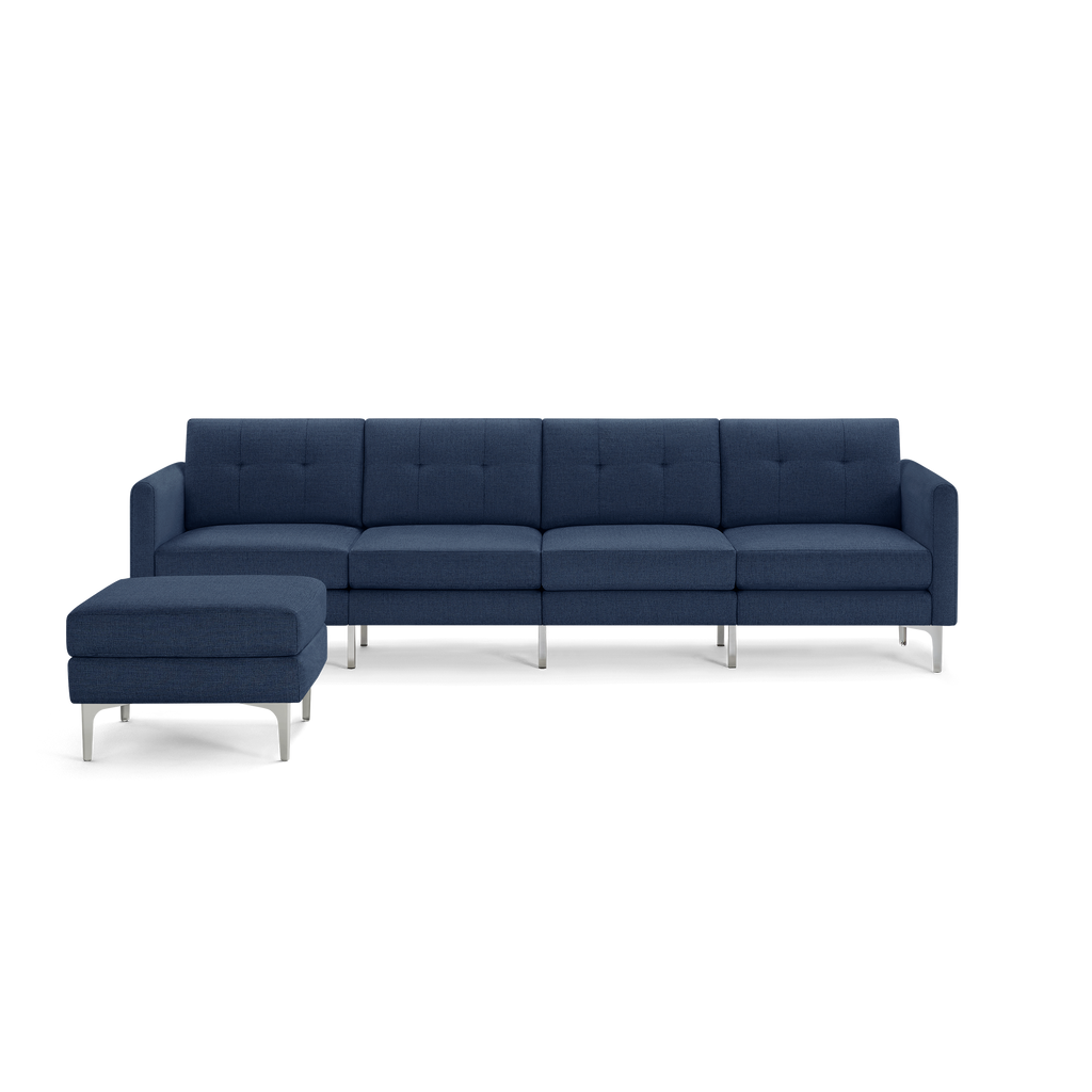 Modern sectional sofa with navy blue upholstery, tufted back cushions, and metal legs, accompanied by a matching ottoman.