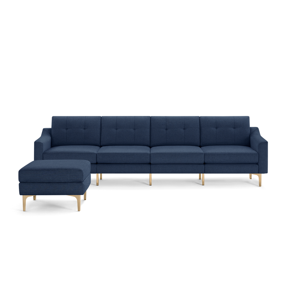 Modern navy blue sectional sofa with tufted cushions, wooden legs, and a matching ottoman on the left side.