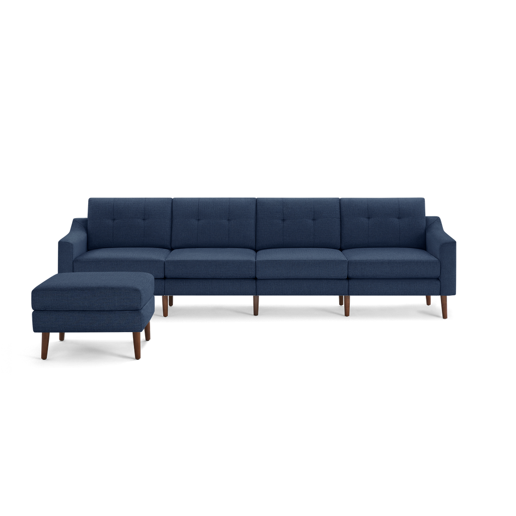Modern navy blue sectional sofa with tufted back cushions, wooden legs, and matching ottoman on left side.