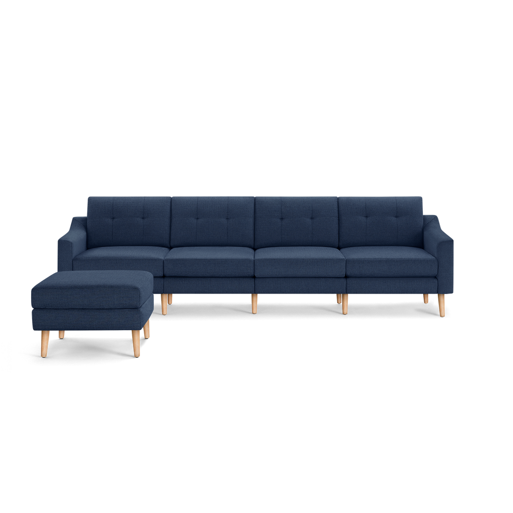 Modern navy blue sectional sofa with wooden legs and matching ottoman, featuring tufted cushions and a sleek, minimalist design.