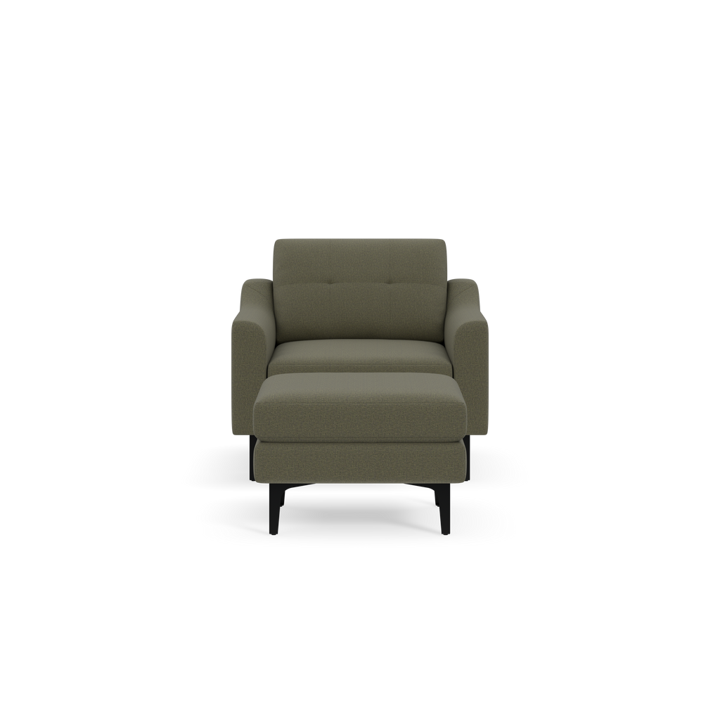 Modern Moss green upholstered armchair with padded cushions, square arms, and angled black legs, shown against black background.