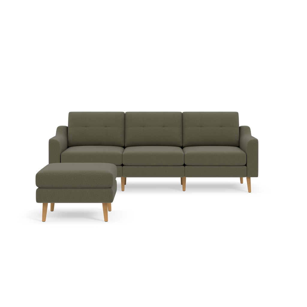 Green sectional sofa with tufted back cushions and wooden legs, accompanied by a matching ottoman on a black background.