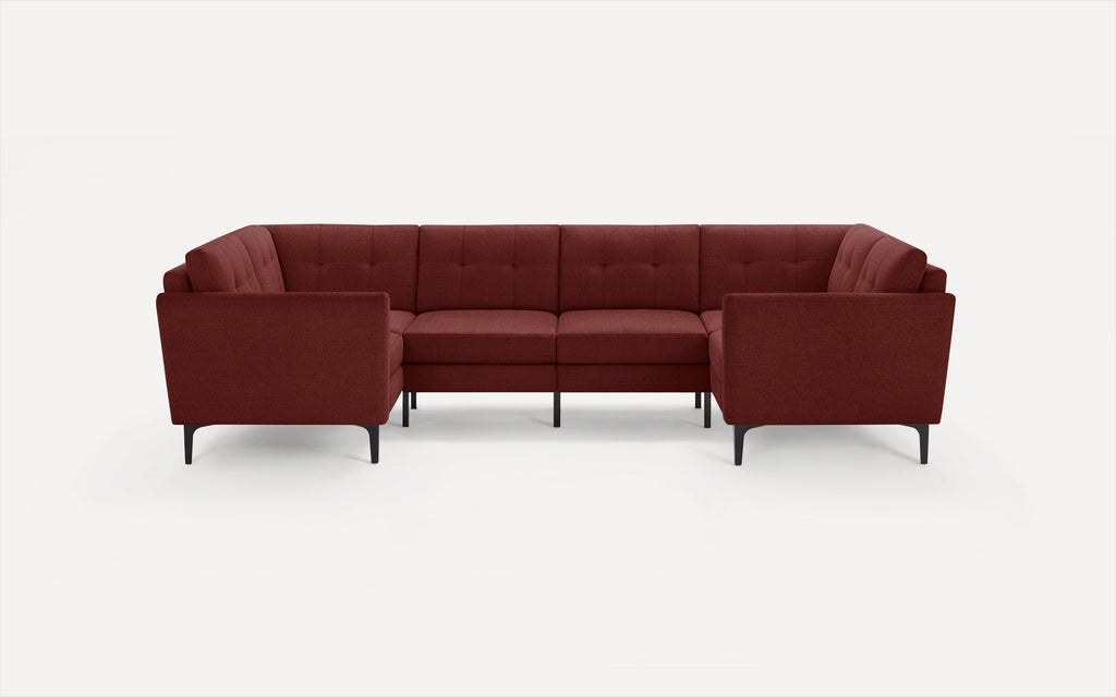 Modern L-shaped sectional sofa in deep red fabric with tufted cushions and slim black metal legs on white background.