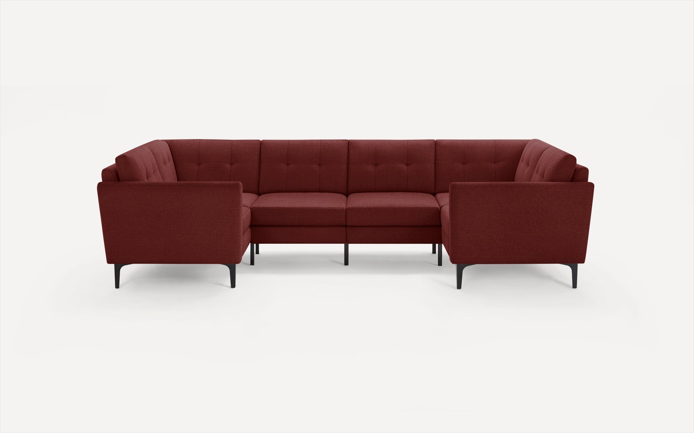Modern L-shaped sectional sofa in deep red fabric with tufted cushions and slim black metal legs on white background.