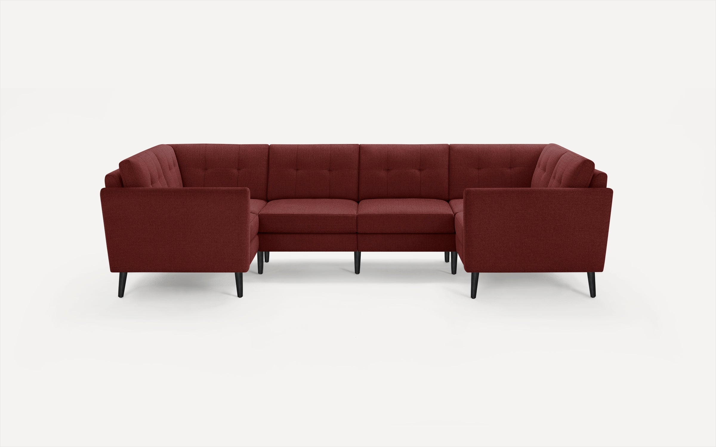 Modern U-shaped sectional sofa with deep red upholstery, tufted cushions, and sleek black tapered legs on a white background.