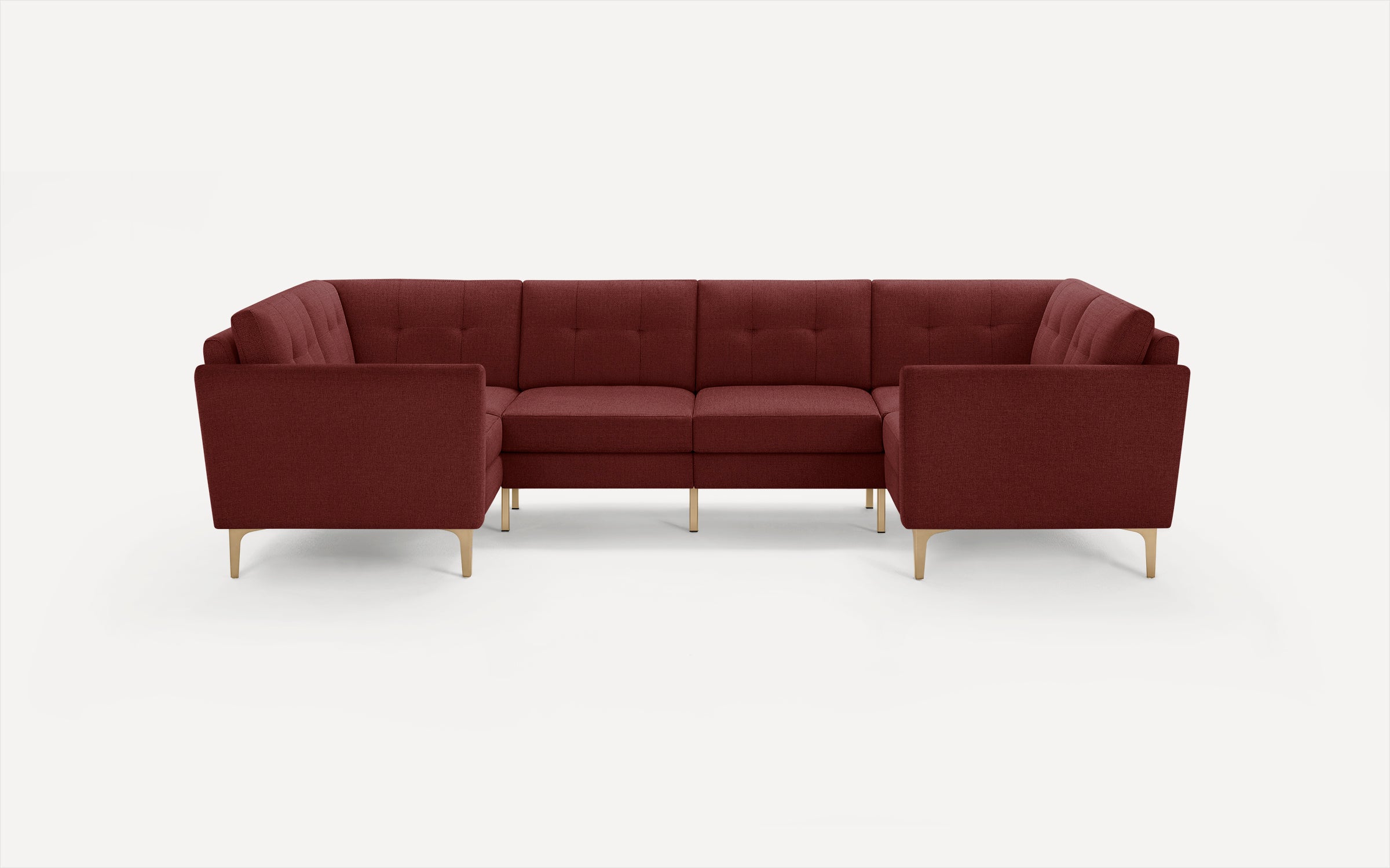 Modern burgundy fabric sectional sofa with tufted cushions and slim gold metal legs on a white background.