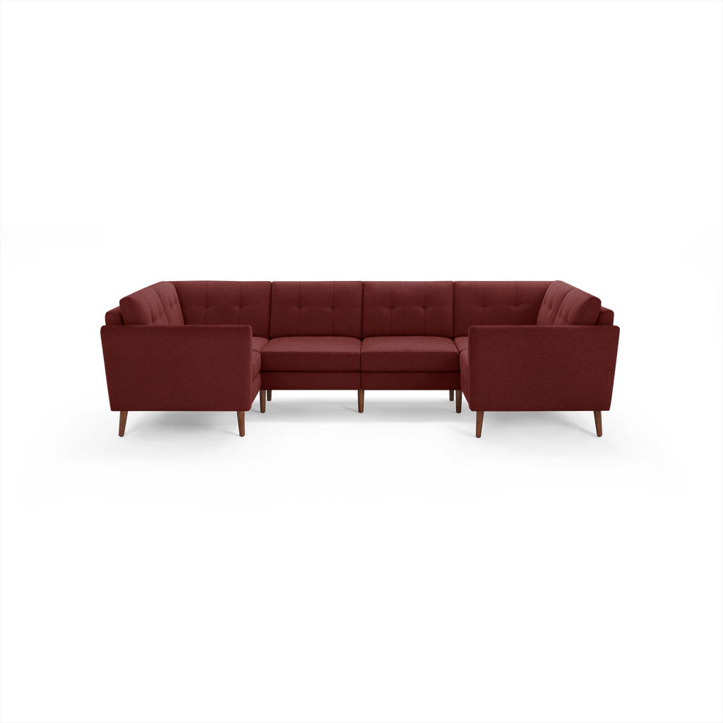 Modern U-shaped sectional sofa in deep red fabric with tufted back cushions and wooden legs, suitable for spacious living rooms.