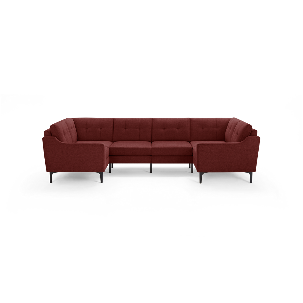 Modern U-shaped sectional sofa in deep burgundy fabric with tufted back cushions and black metal legs.