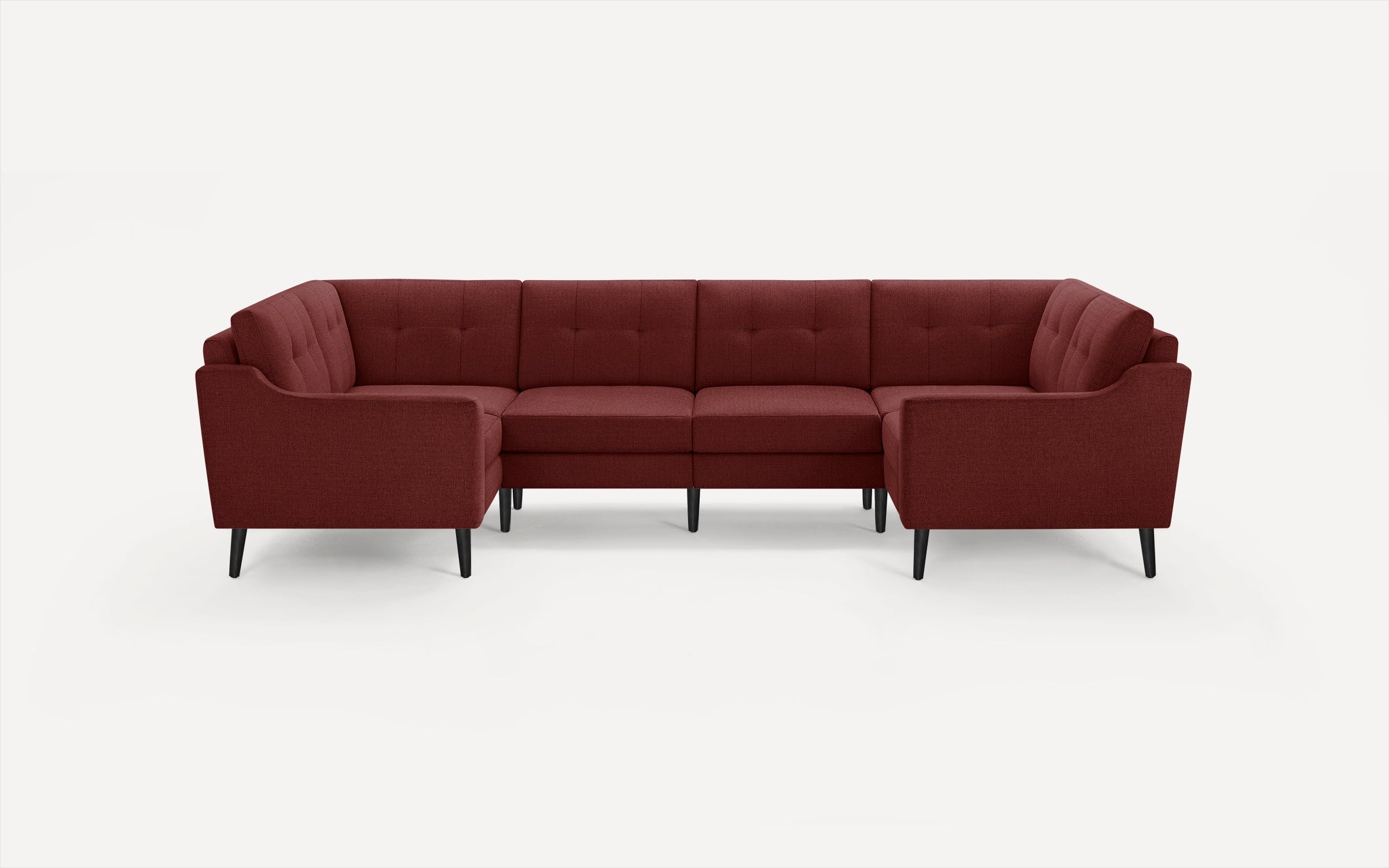 Modern L-shaped sectional sofa in deep red fabric with tufted back cushions and black tapered legs, against white background.