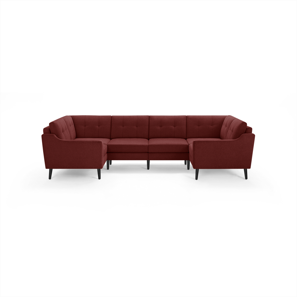 Large U-shaped sectional sofa in deep red fabric with tufted backrests and black tapered legs, modern and spacious.