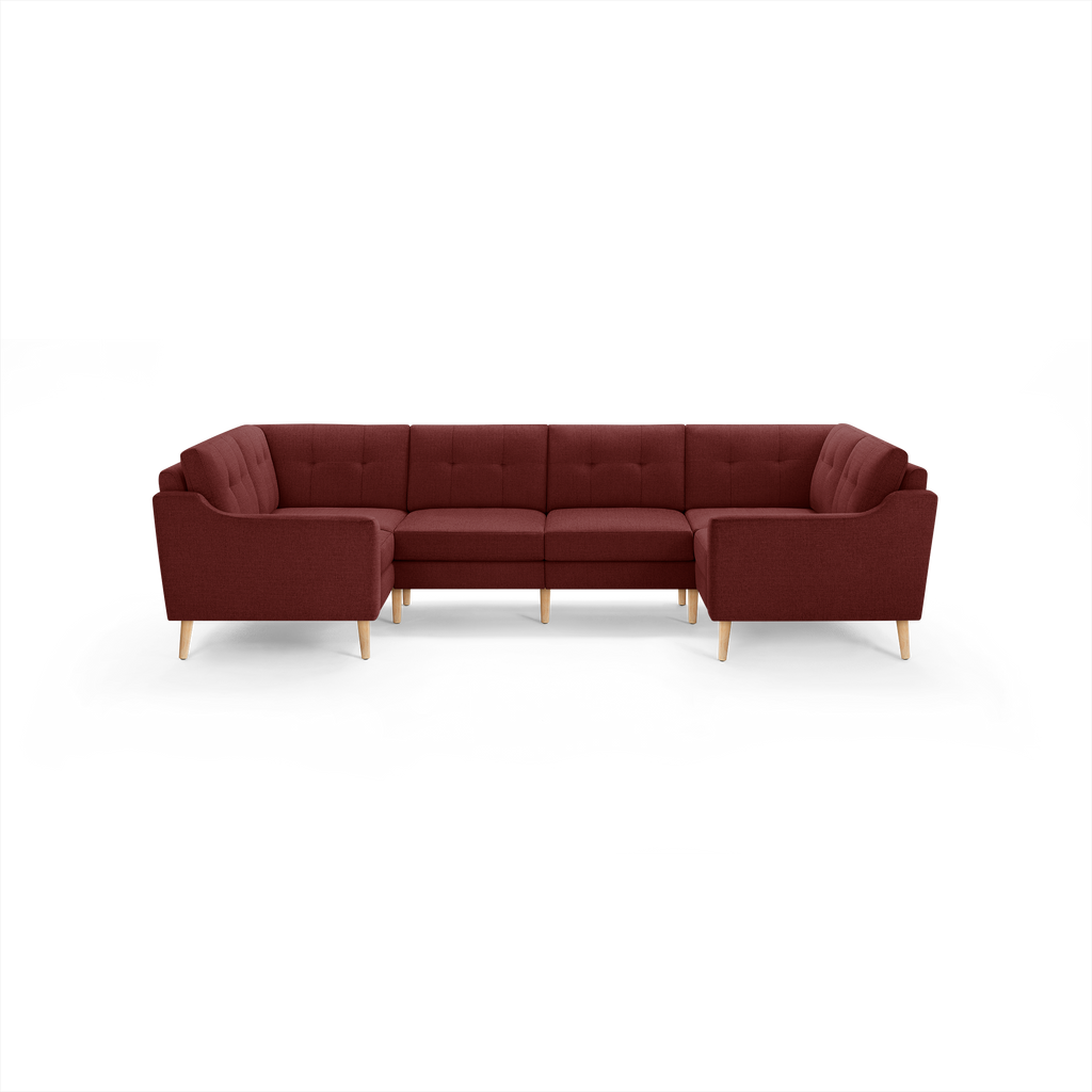 U-shaped sectional sofa in deep red fabric with tufted cushions and light wooden legs, modern and cozy design.