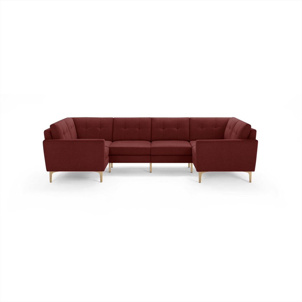 Modern U-shaped sectional sofa in deep red fabric with tufted cushions and light wooden legs, providing ample seating.