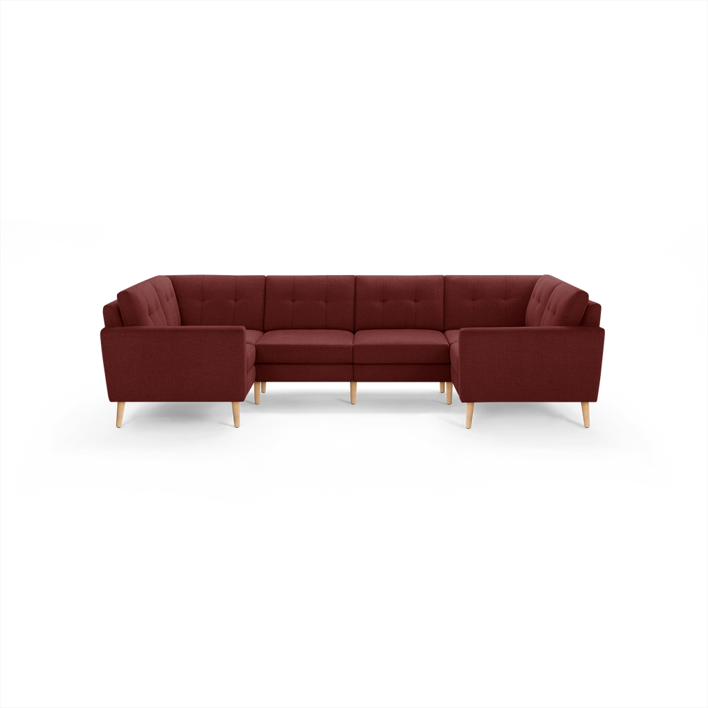 U-shaped sectional sofa in deep red fabric with tufted back cushions and light wooden legs, modern and cozy design.